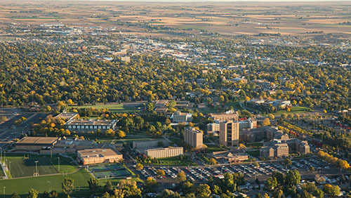 Aerial view showcasing the University of Northern Colorado surrounded by expansive greenery and urban development.