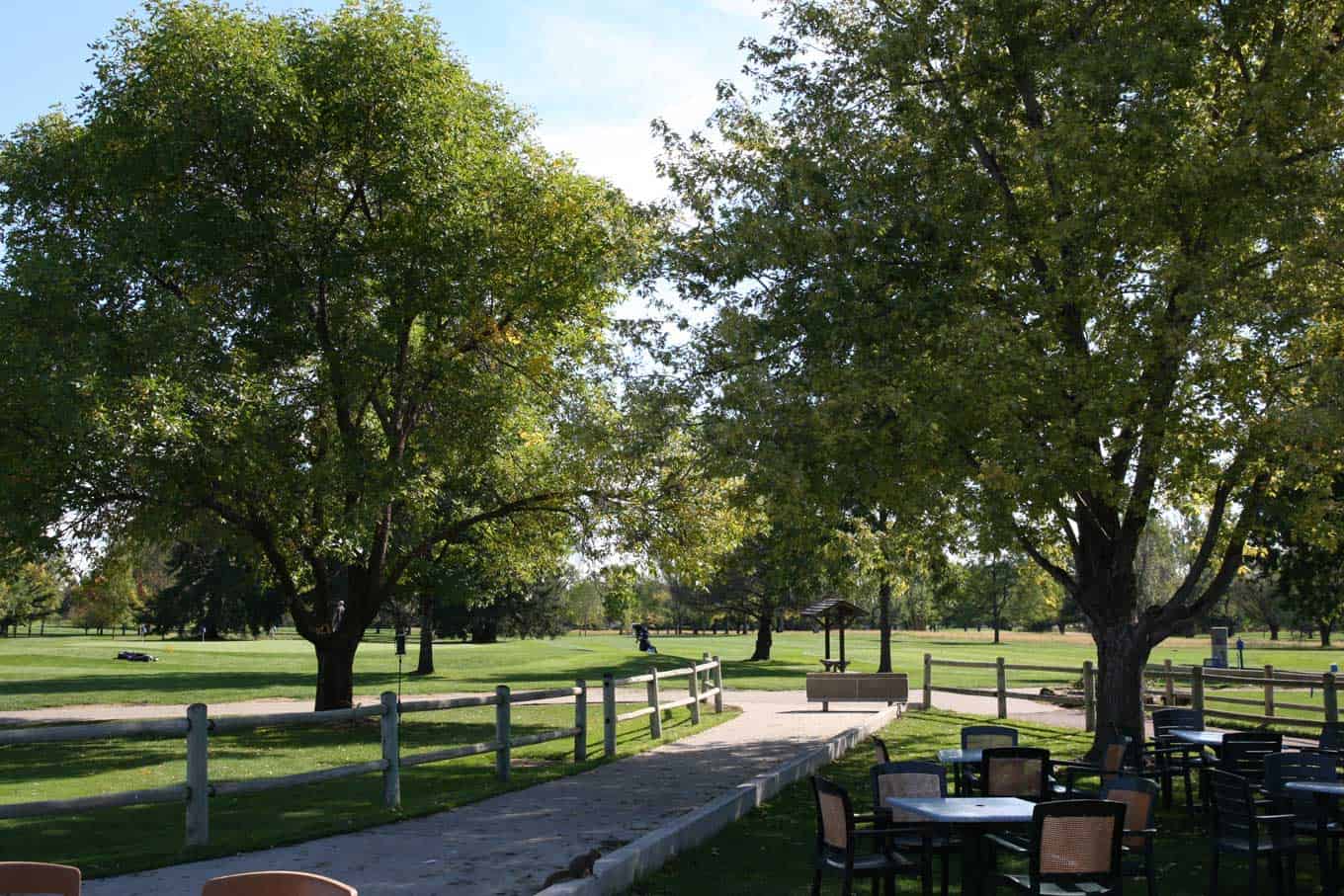 A serene golf trail surrounded by lush greenery with outdoor seating and walking paths.