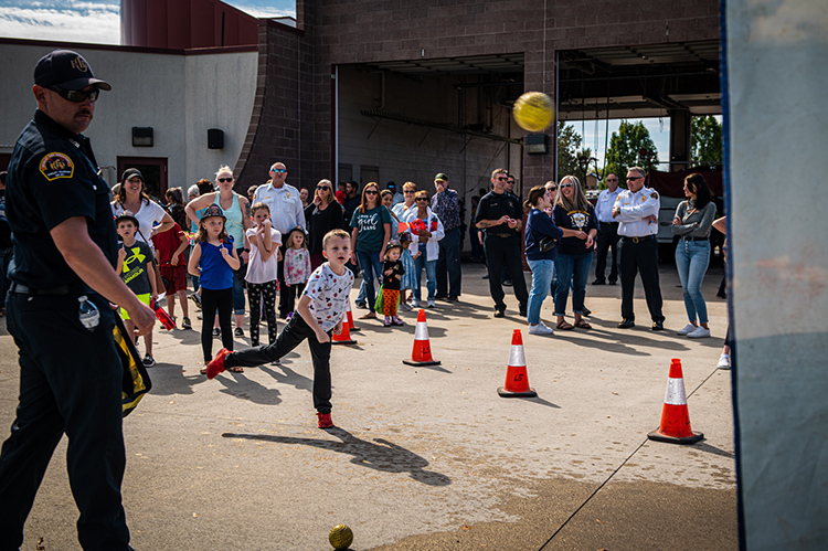 Community members gather as children participate in an activity at the fire department open house event.