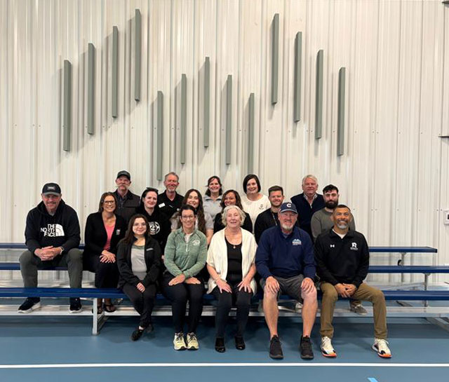 Employees from the City of Greeley’s Culture, Parks and Recreation Department and United Way pose for a photograph while seated on bleachers after the Weld County Recreation Scholarship event reception.