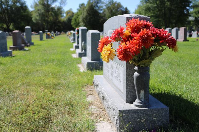 Headstones with flowers after clean up week at Linn Grove Cemetery