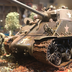 A detailed model showcasing a World War II tank and soldiers in a historical setting.