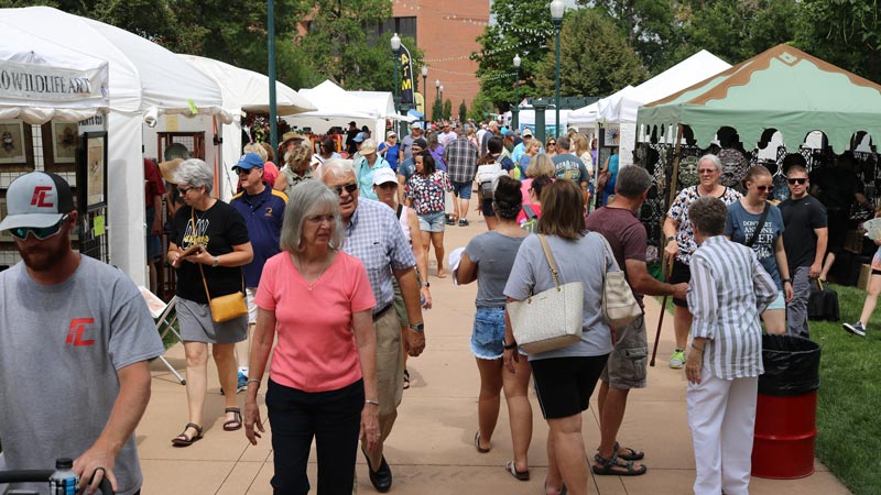 Residents explore various booths at Lincoln Park during the Arts Picnic event.