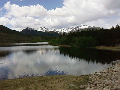 A picturesque reservoir surrounded by mountains and greenery reflecting the beauty of nature.