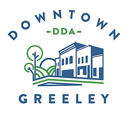 This image depicts the logo of the City of Greeley's Downtown Development Authority, or DDA.  The logo is blue and green in color.  In the center of the logo is a blue and green line drawing of downtown buildings and trees.  Above the drawing is the word "DOWNTOWN" in blue capital letters, with the acronym "DDA" directly below in green capital letters.  Under the drawing is the word "GREELEY" in blue capital letters.