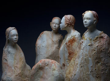 A close-up of sculpted clay figures with a textured surface, highlighting craftsmanship and detailing.
